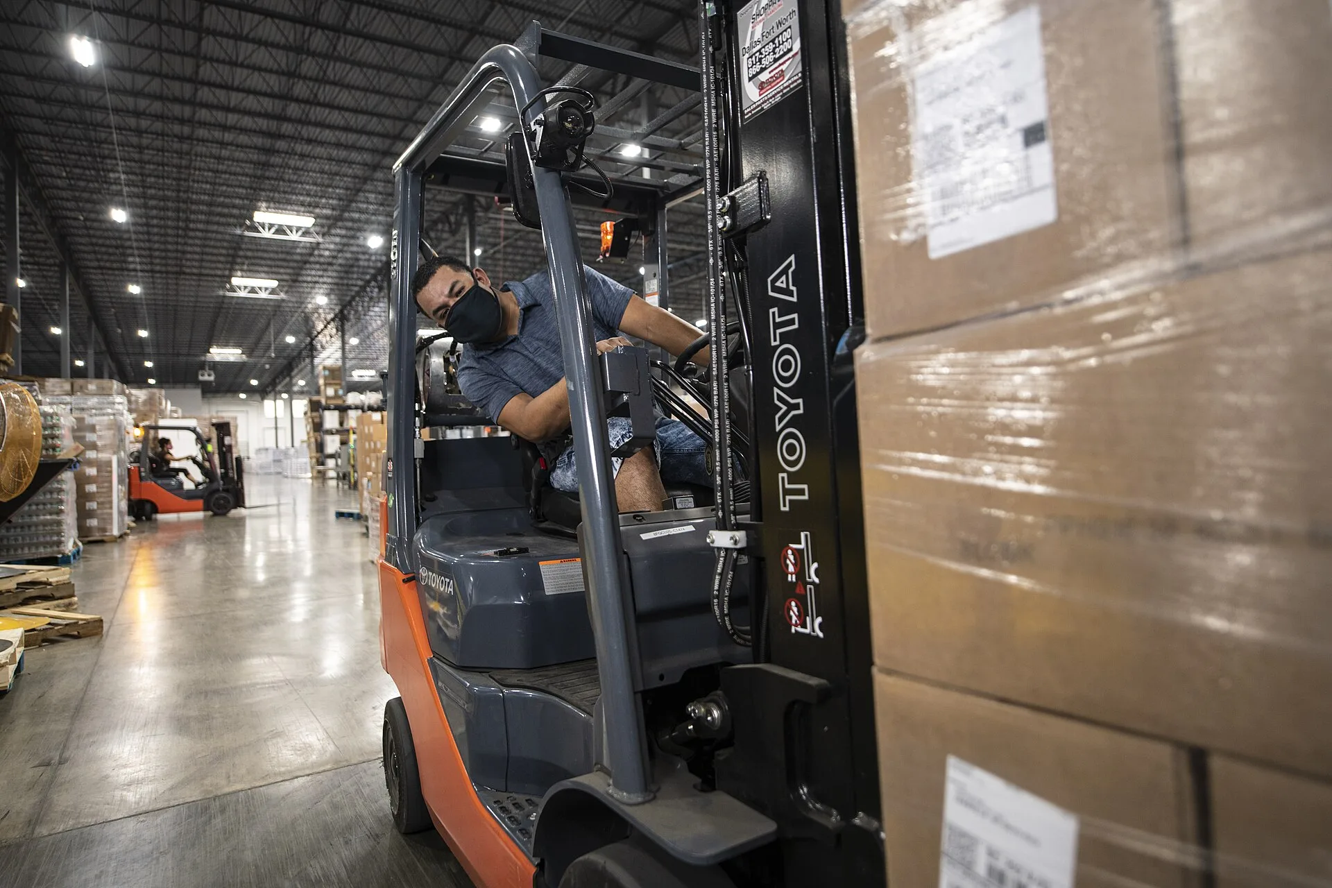 Forklift moving boxed cargo in a warehouse